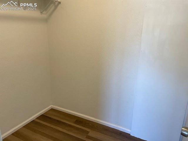Image 10 of 21: Spacious closet with dark wood finished floors