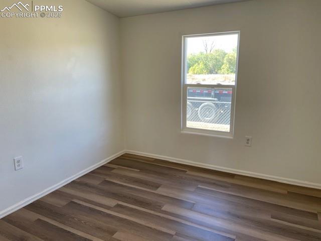 Image 11 of 21: Spare room featuring dark wood-style floors and baseboards