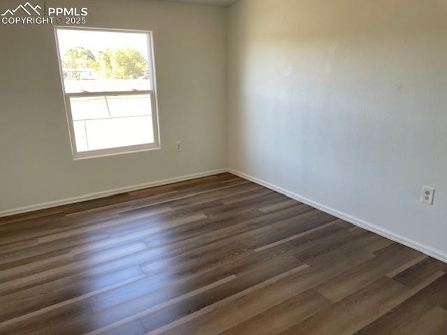 Image 12 of 21: Spare room with dark wood-style floors and baseboards