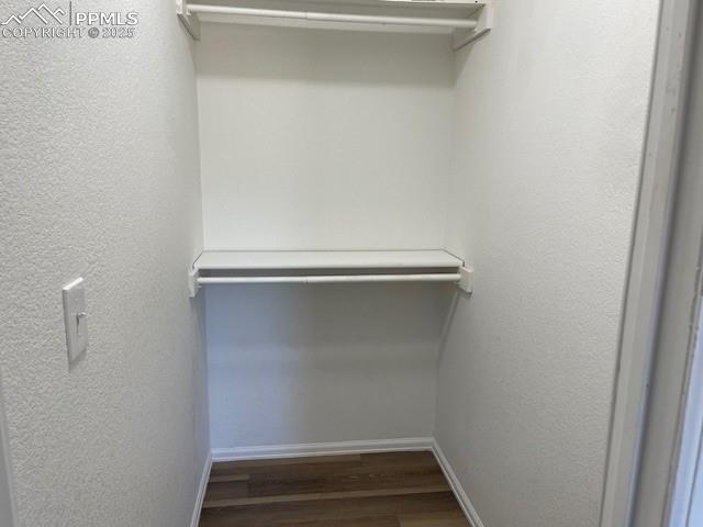 Image 19 of 21: Spacious closet with wood finished floors