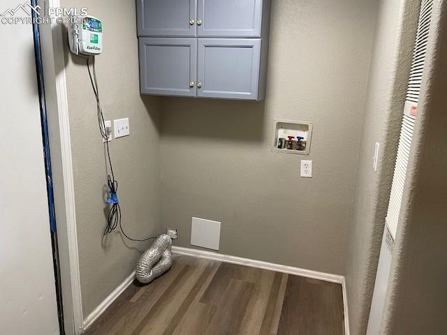 Image 21 of 21: Laundry area with washer hookup, cabinet space, wood finished floors, hooku