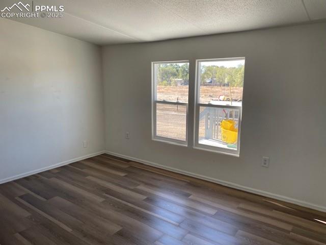 Image 3 of 21: Empty room featuring dark wood-style flooring and a textured ceiling
