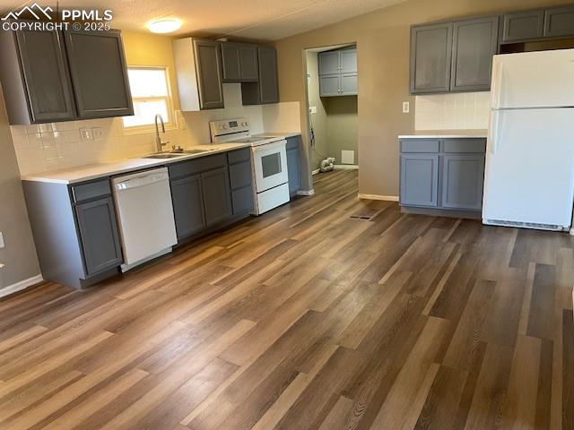 Image 7 of 21: Kitchen with decorative backsplash, white appliances, dark wood-style floor
