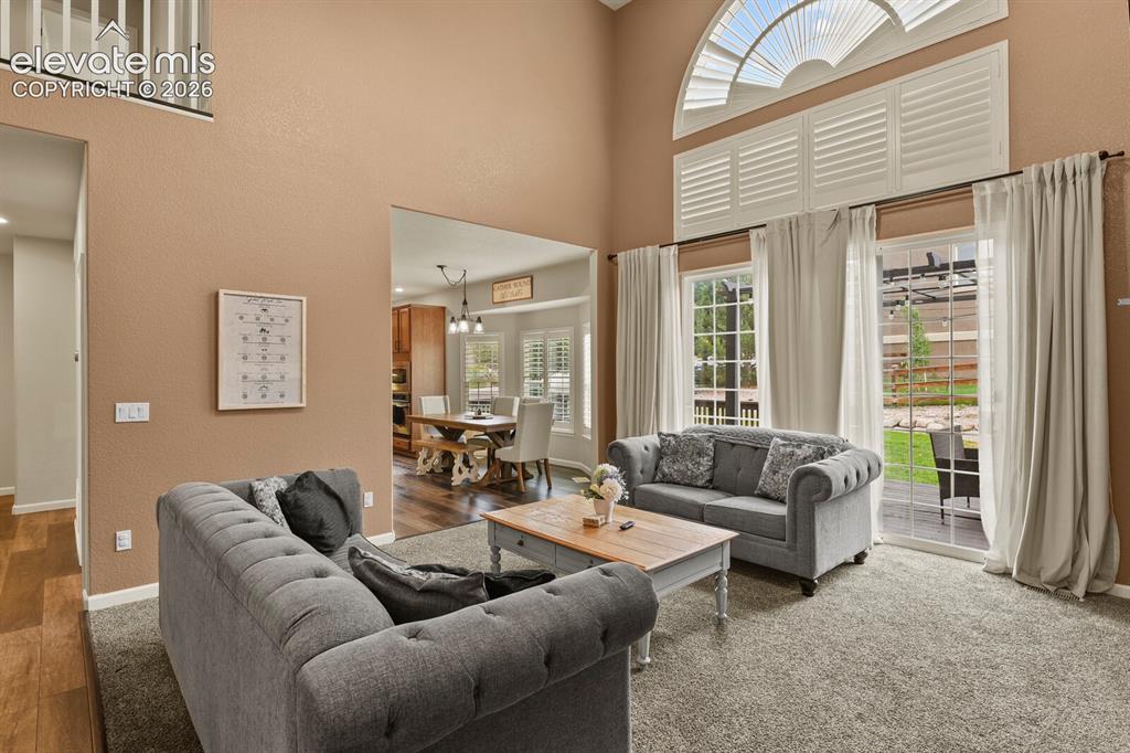 Image 11 of 47: Vaulted living space with a large arched transom window and plantation shut