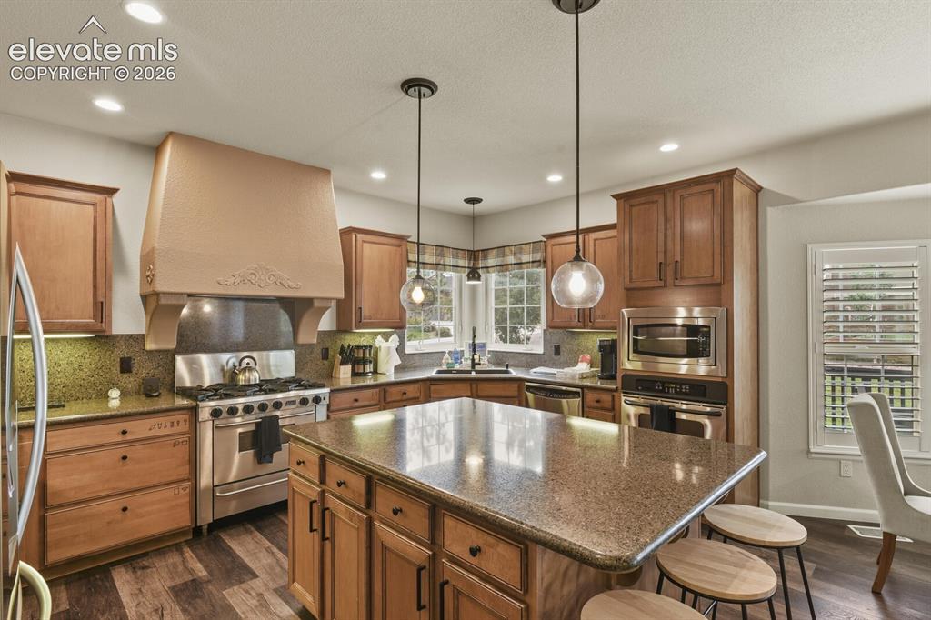 Image 16 of 47: Spacious kitchen featuring wood cabinetry, stainless steel appliances, gran