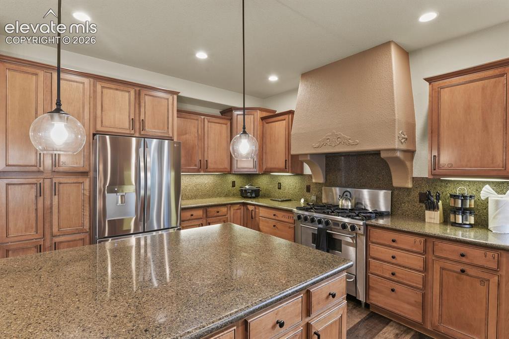 Image 19 of 47: Gourmet kitchen featuring a substantial central island with a stone-finish 