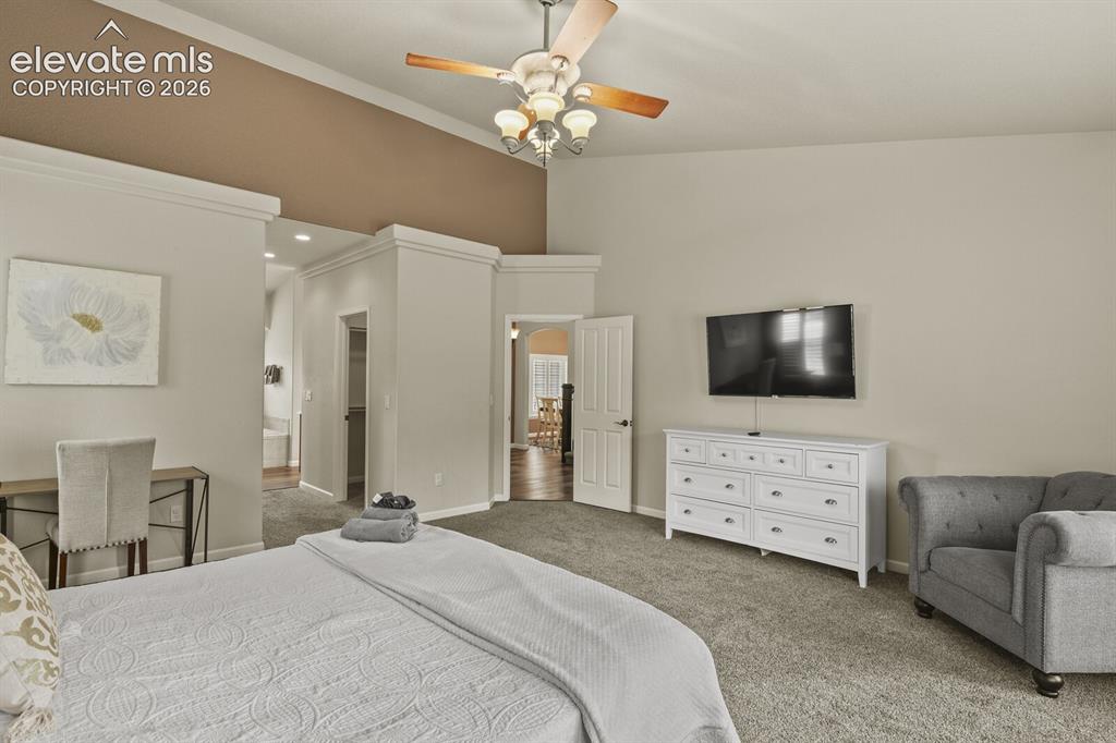 Image 21 of 47: Spacious room featuring vaulted ceilings, a ceiling fan with integrated lig