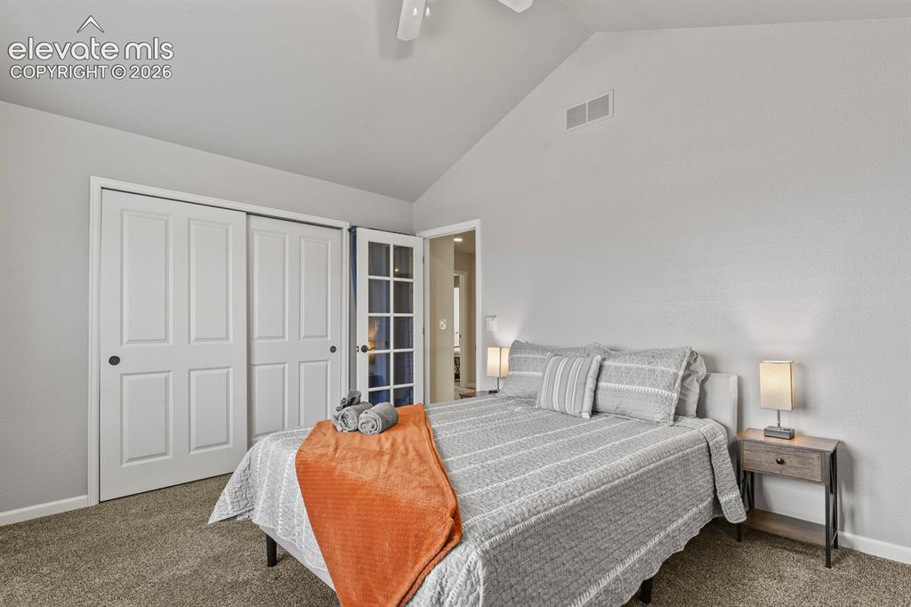 Image 28 of 47: Vaulted ceiling with a ceiling fan, light gray wall tones, plush gray carpe
