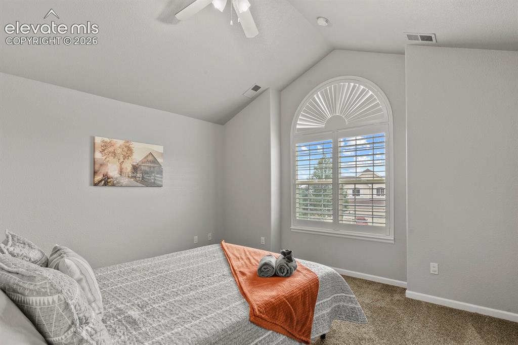 Image 29 of 47: Vaulted ceilings and an arched window featuring plantation shutters