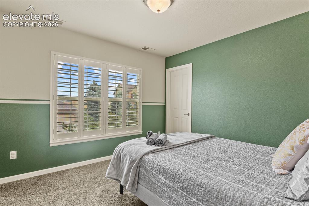 Image 33 of 47: Window featuring plantation shutters and a residential exterior view