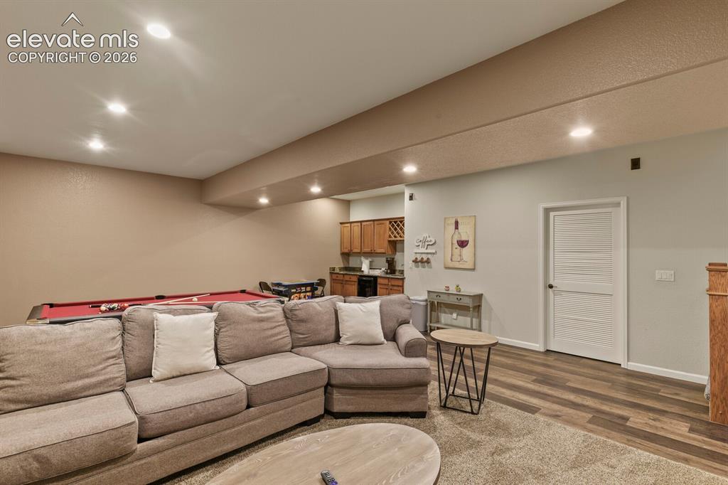 Image 38 of 47: Spacious entertainment area featuring recessed lighting, a built-in wet bar