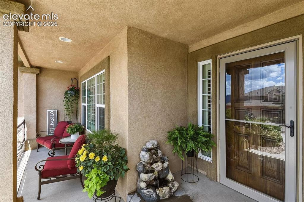 Image 4 of 47: Covered porch featuring stucco exterior, recessed lighting, a paneled wood 