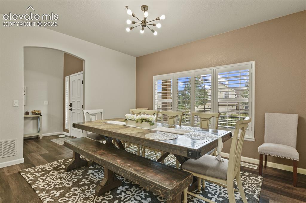 Image 9 of 47: Dining area featuring wood-finish flooring, a contemporary chandelier, and 