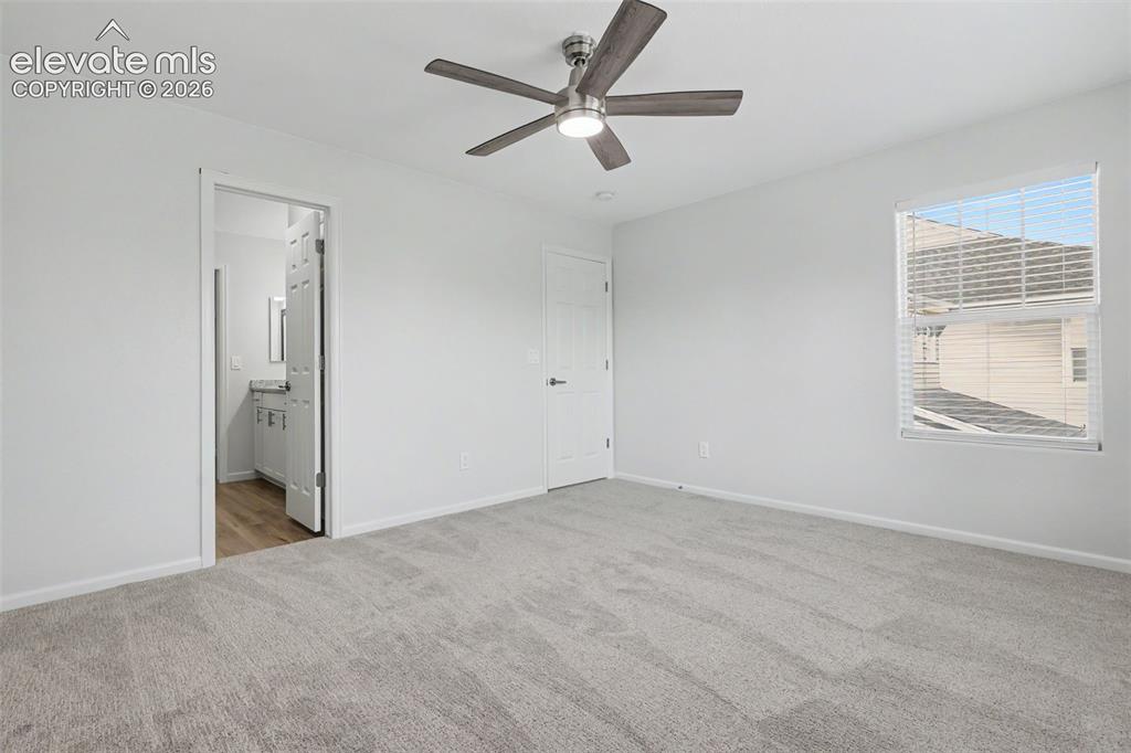 Image 16 of 27: Spacious room with three large windows and ceiling fan, adjoining bath and