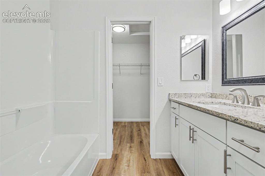 Image 17 of 27: Bathroom featuring a single vanity with granite counter, white shaker cabin
