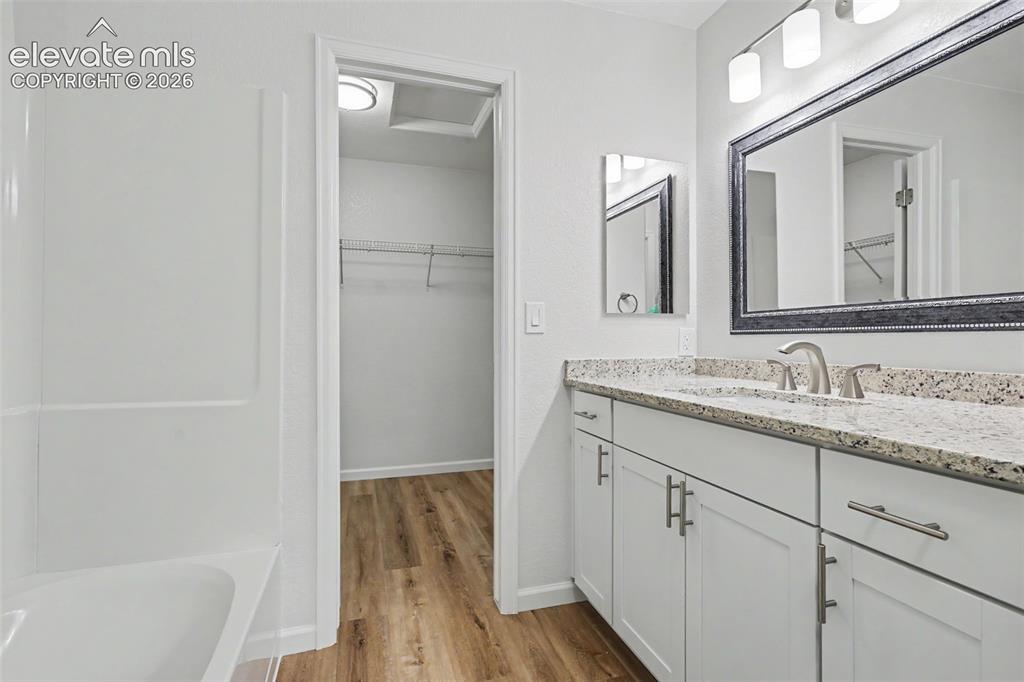 Image 18 of 25: Bathroom featuring a single vanity with granite counter, white shaker cabin