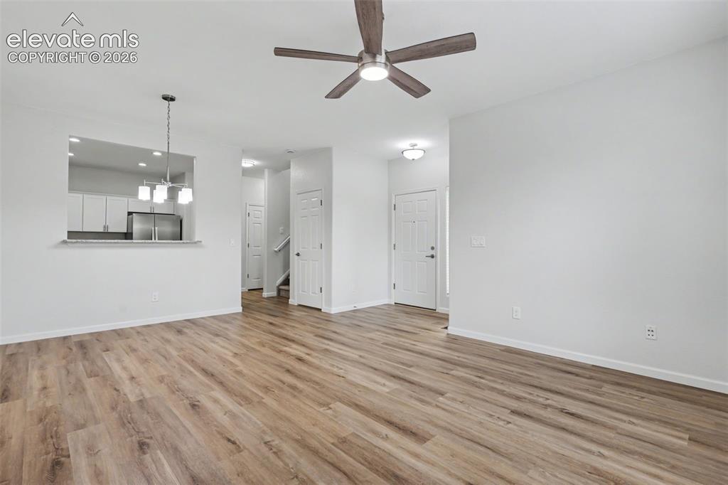 Image 5 of 27: Expansive living area featuring LVP flooring, a ceiling fan with integrated