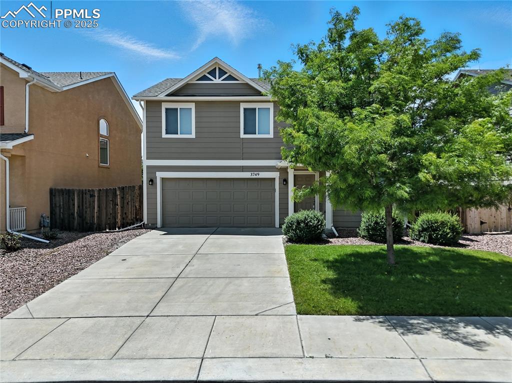 Caption: View of front facade featuring a garage and driveway