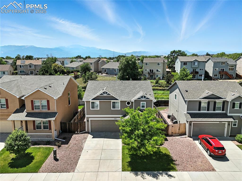 Image 2 of 46: Aerial perspective of suburban area with a mountainous background