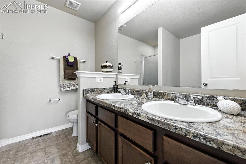 Image 21 of 46: Full bathroom featuring a stall shower and double vanity