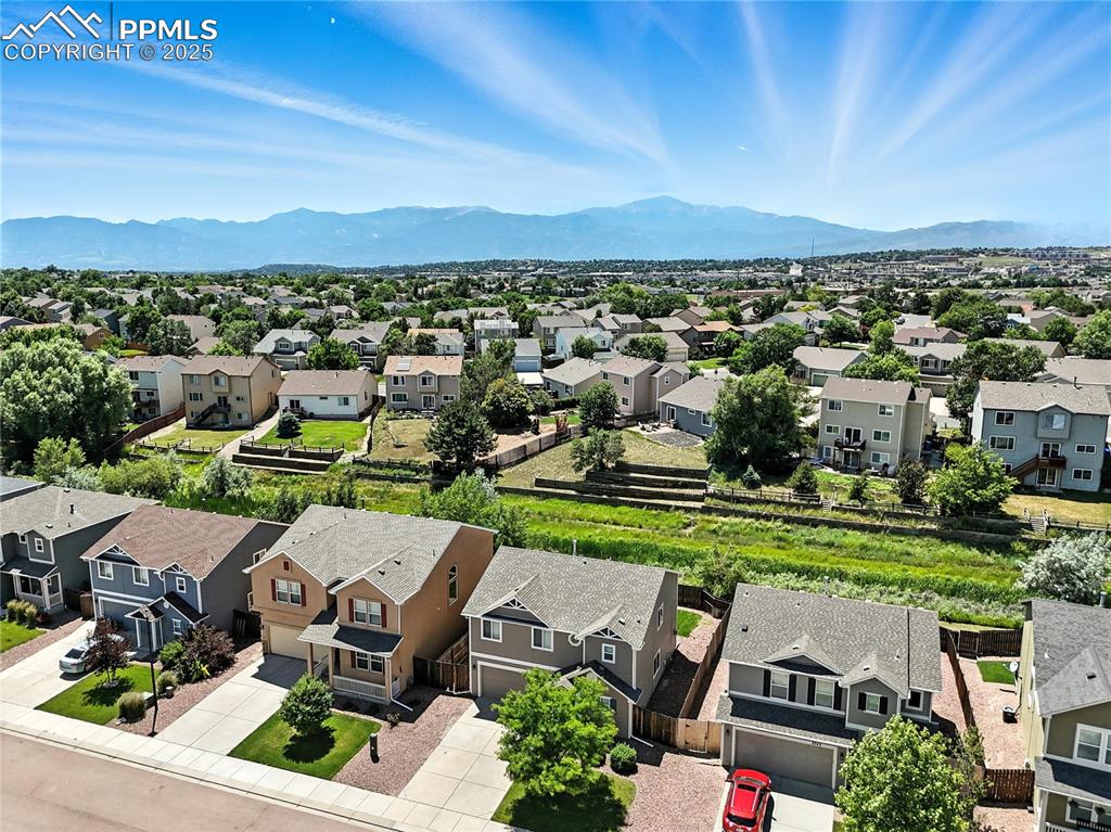 Image 32 of 46: Aerial perspective of suburban area featuring a mountainous background