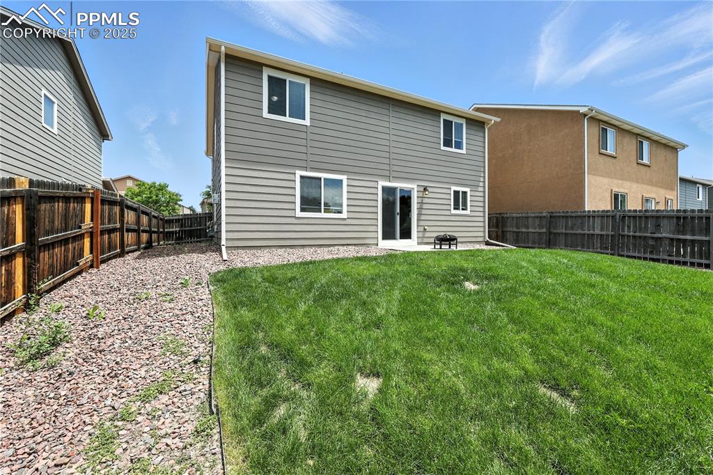 Image 39 of 46: Rear view of house with a fenced backyard and a patio