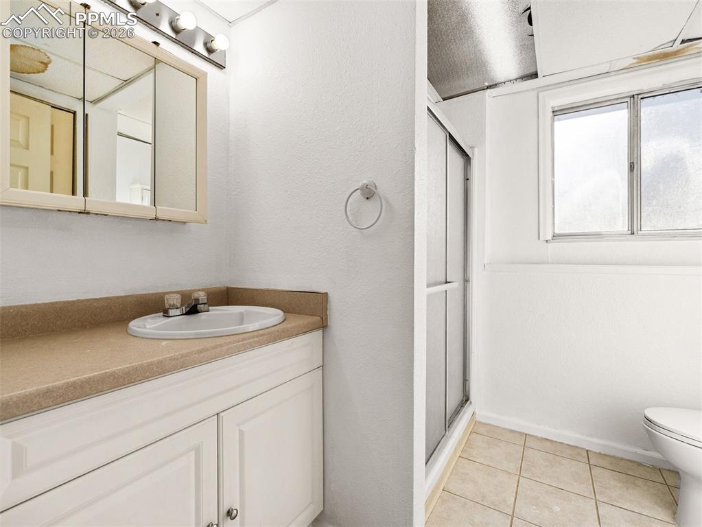 Image 11 of 30: Full bath featuring vanity, a stall shower, light tile patterned flooring, 