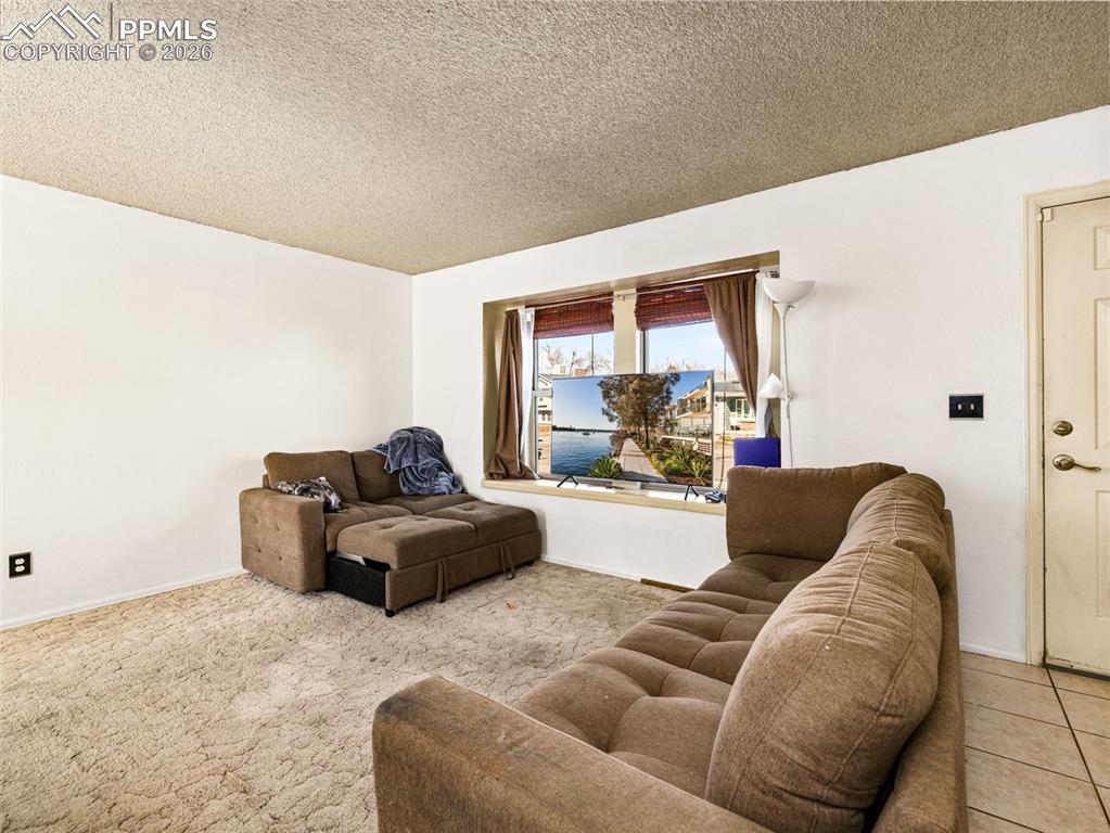 Image 4 of 30: Living area with a textured ceiling