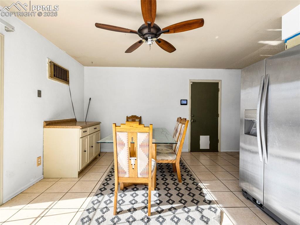 Image 8 of 30: Dining room with ceiling fan and light tile patterned floors
