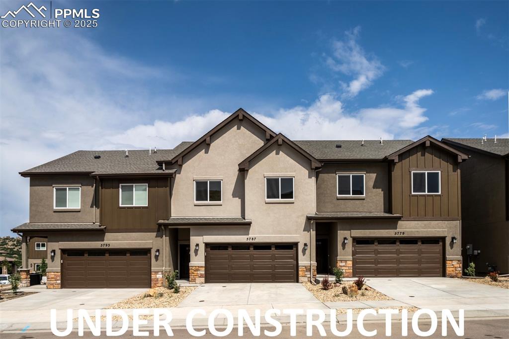 Caption: Three-unit stucco building with stone and board-and-bat accents.