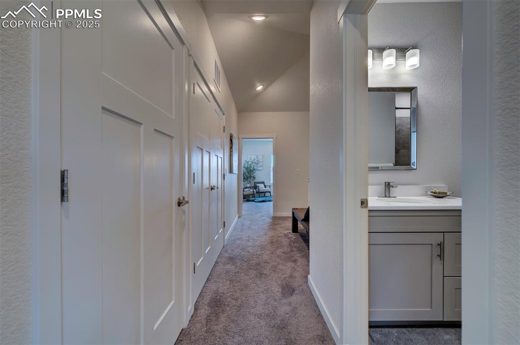 Image 23 of 42: Upstairs hallway looking towards the primary bedroom and stairs.