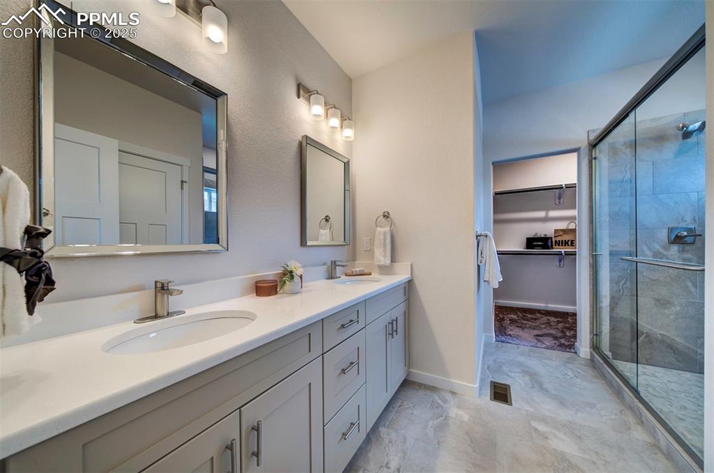 Image 28 of 42: Bathroom has dual vanity, drawers, and a large shower.