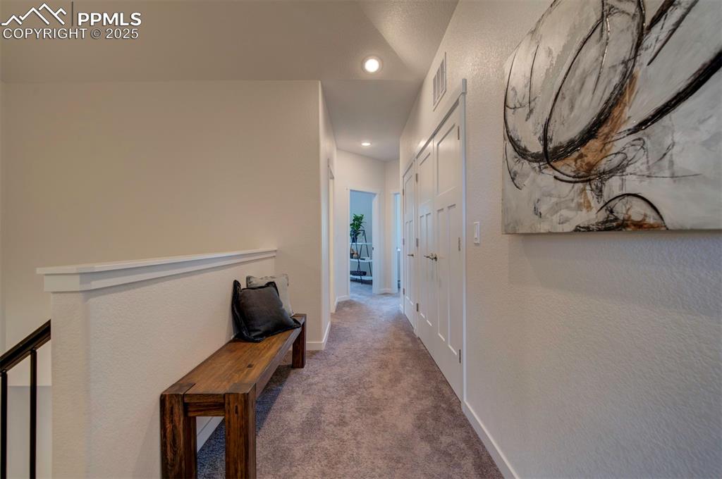 Image 31 of 42: Hallway looking from the primary bedroom and stairs towards the other two b