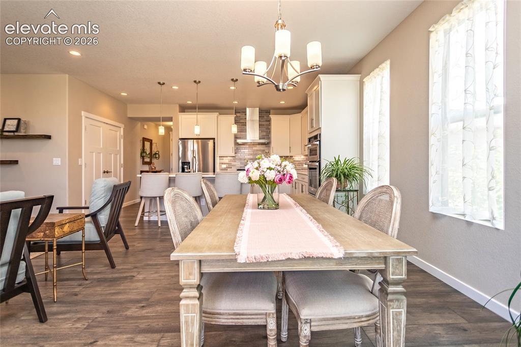 Image 22 of 23: Open-concept living area with wood-finish flooring, recessed lighting, and 