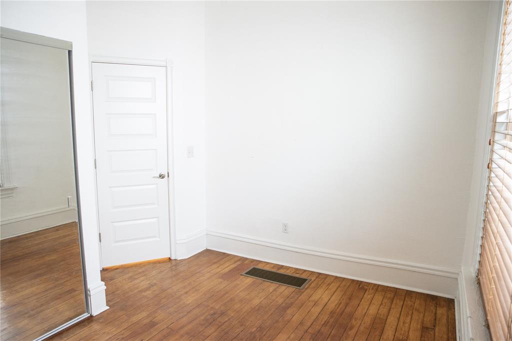 Image 9 of 15: Room featuring hardwood floors, white walls, and a window with blinds