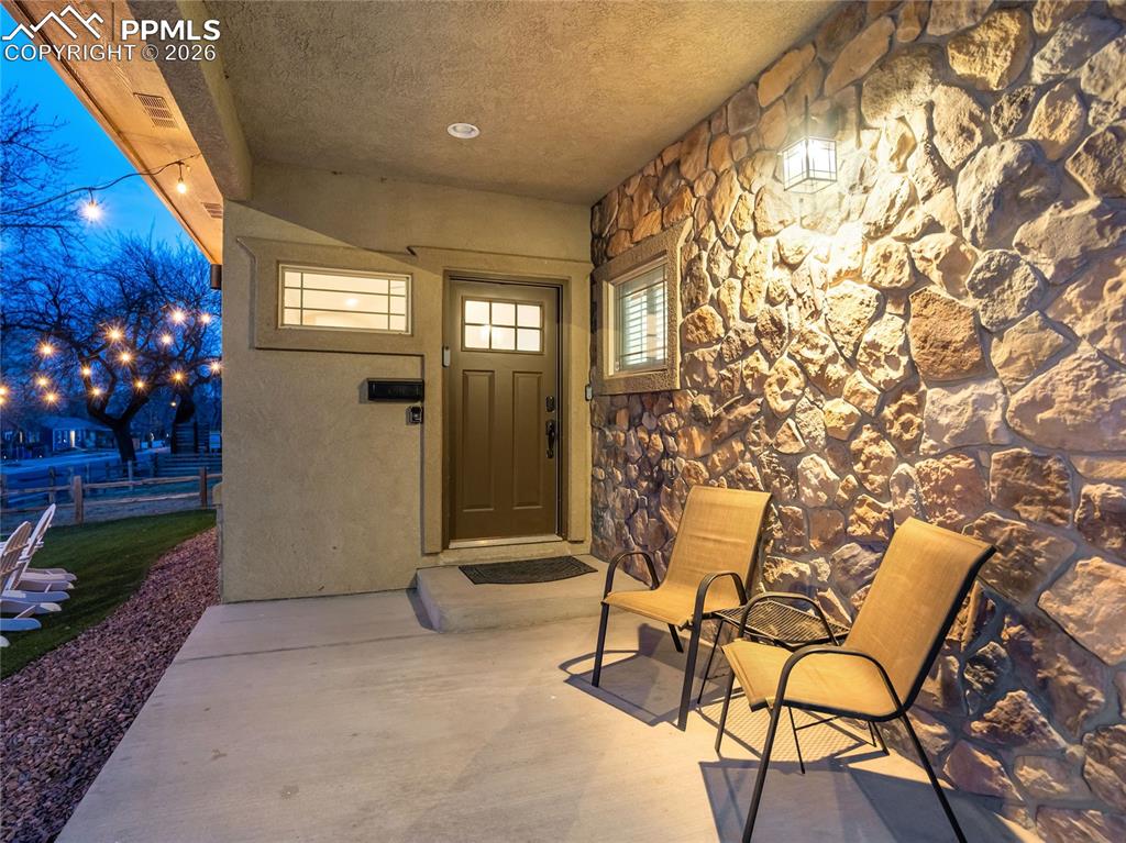 Image 4 of 47: Covered front porch entry with dramatic stone accent wall provides a welcom