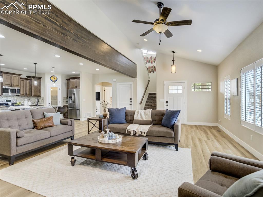 Image 5 of 47: Open-concept living room with beam accent, new LVP floors, and easy flow to