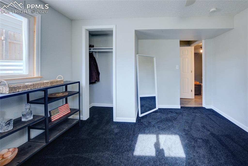 Image 23 of 35: Unfurnished bedroom featuring dark colored carpet, a closet, a ceiling fan,