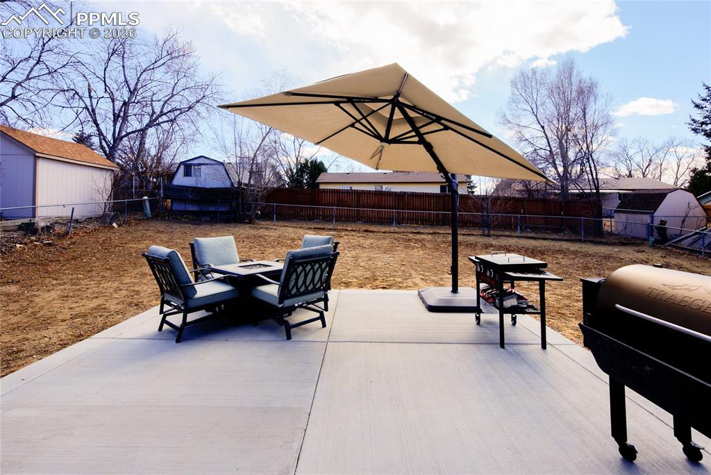 Image 30 of 35: Fenced backyard featuring a patio and grilling area