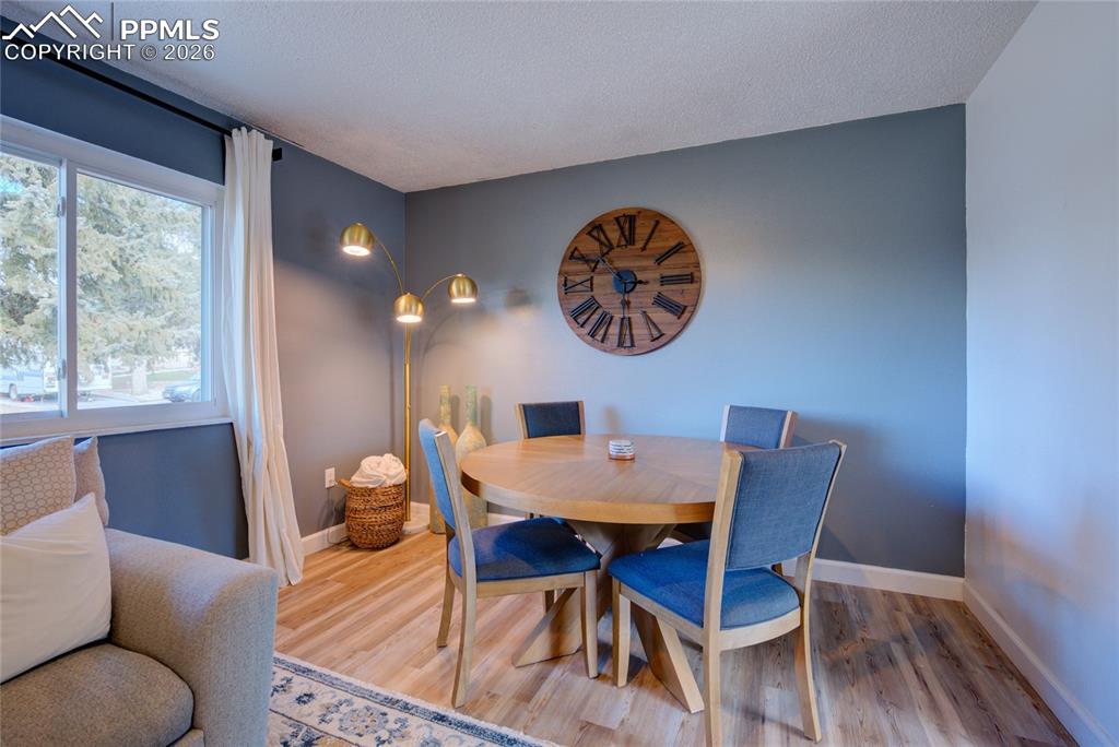 Image 7 of 35: Dining space with wood finished floors and a textured ceiling