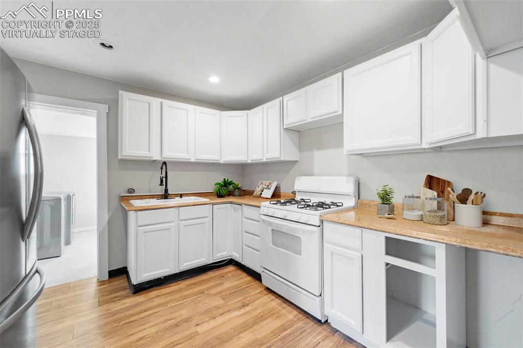 Image 11 of 35: Virtually Staged / Alternate angle of the kitchen showing flow to adjacent