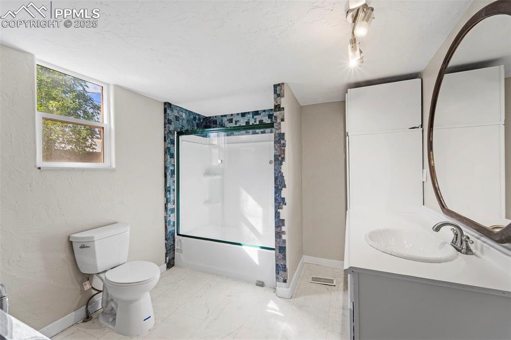 Image 13 of 35: Full bathroom with updated fixtures and stylish tile accents.