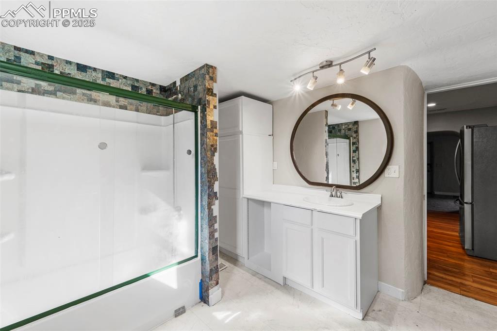 Image 15 of 35: Renovated bath with a walk-in shower and modern vanity.