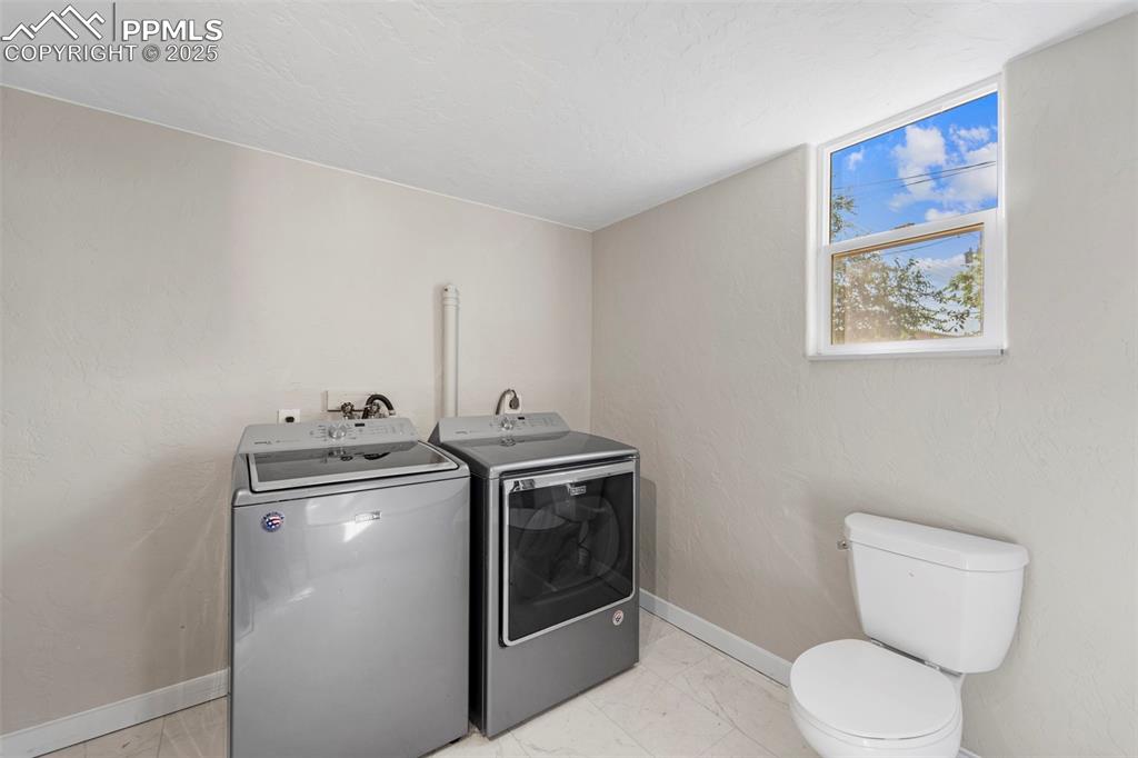 Image 16 of 35: Convenient laundry area with storage and natural light.