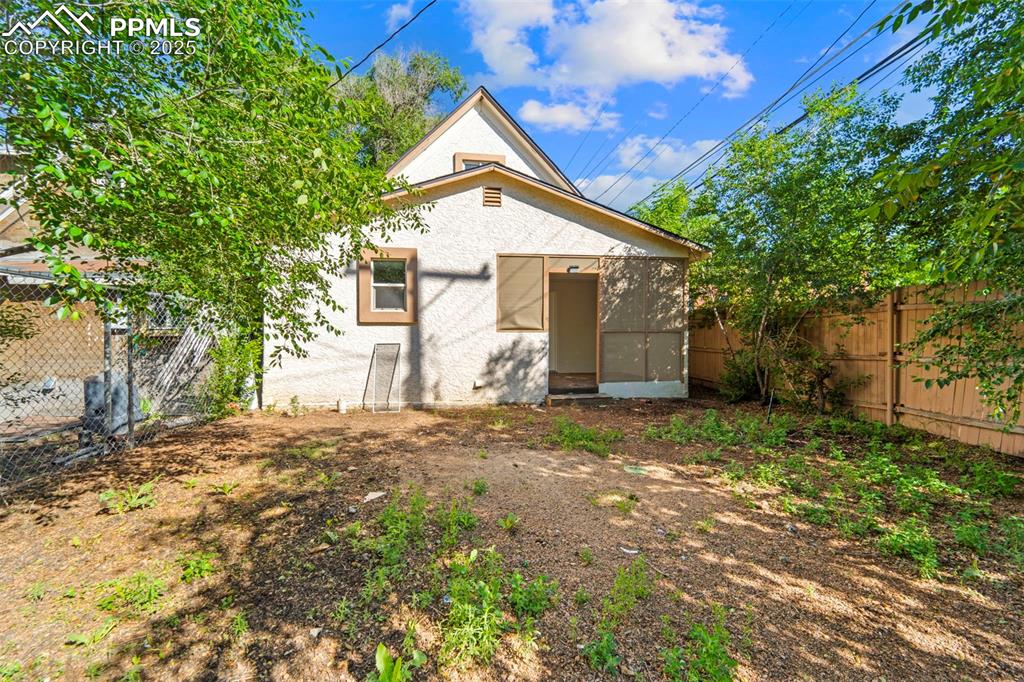 Image 2 of 35: Back view of the home showcasing a spacious lot and private setting.