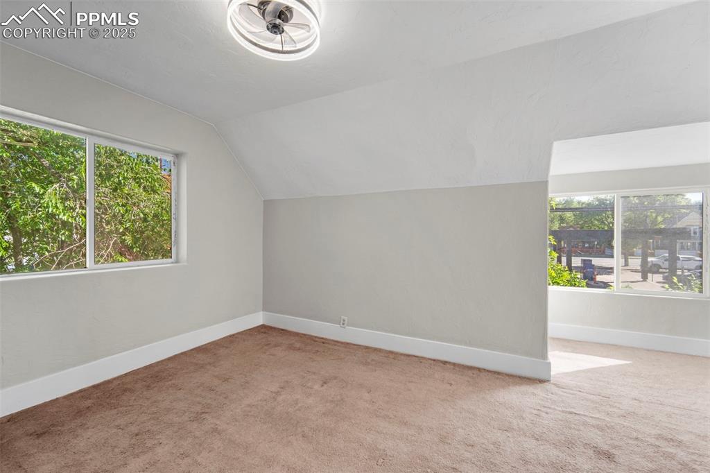 Image 23 of 35: Spacious primary bedroom with large windows and serene views.