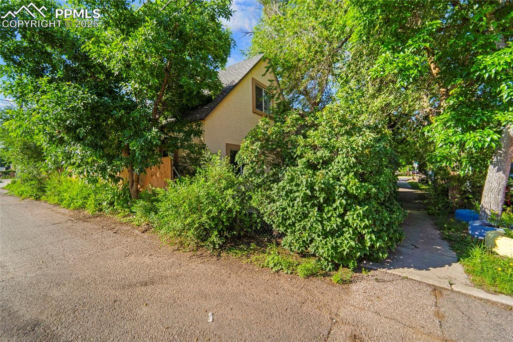 Image 28 of 35: Front elevation with mature trees providing shade and curb appeal.