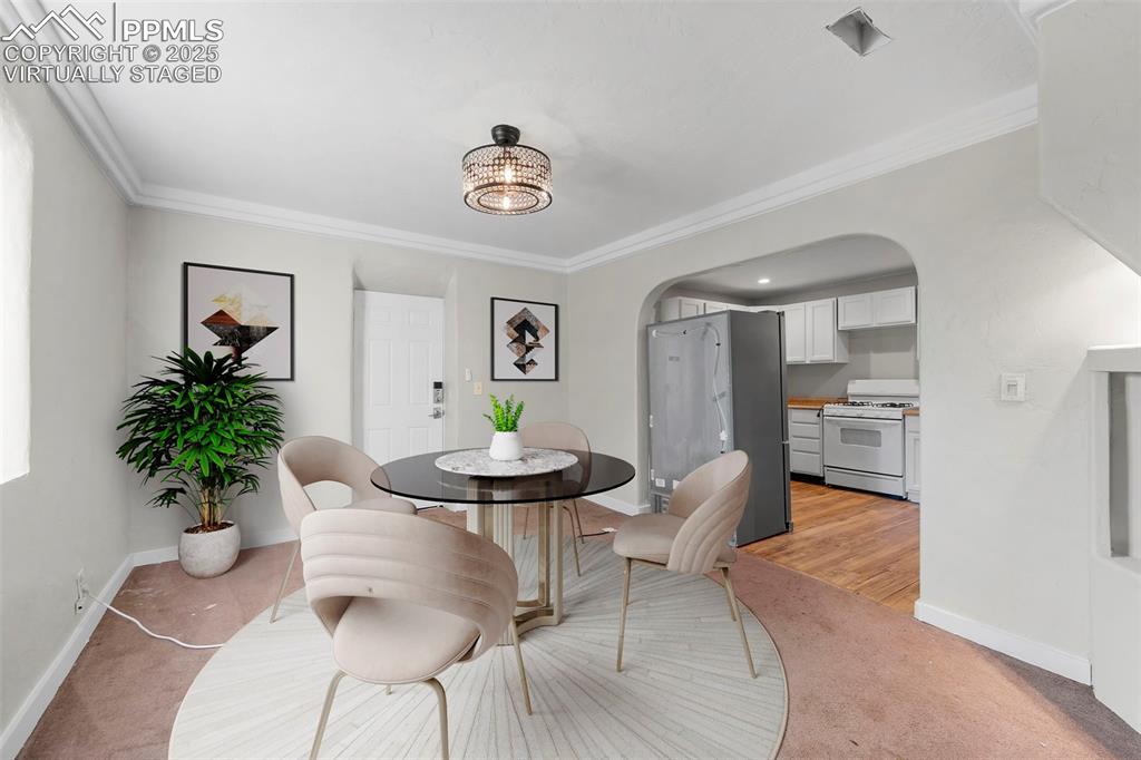 Image 7 of 35: Virtually Staged / Open dining area with stylish lighting and direct kitche