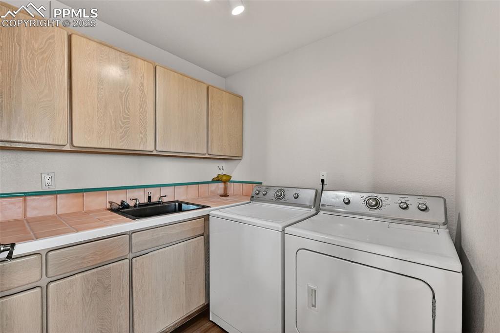 Image 20 of 50: Washroom with cabinet space and washer and dryer