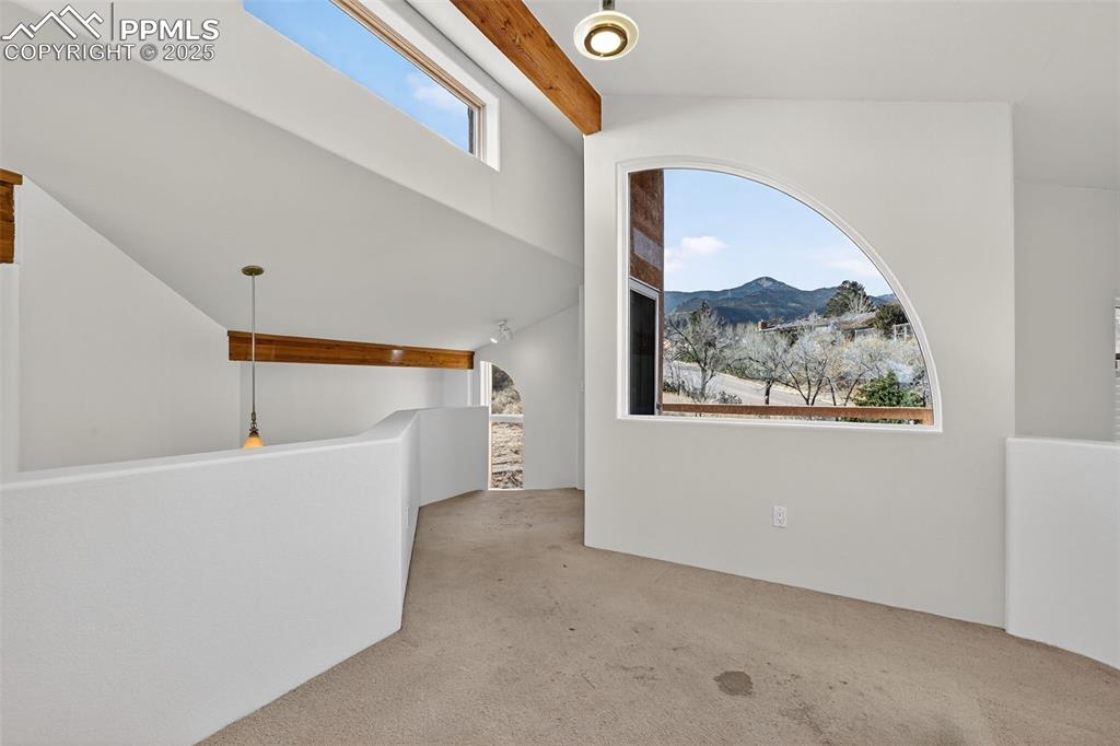 Image 31 of 50: Additional living space featuring a mountain view and carpet flooring (upst